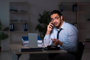 Genç işadamı ofiste geç saatlere kadar çalışıyor.