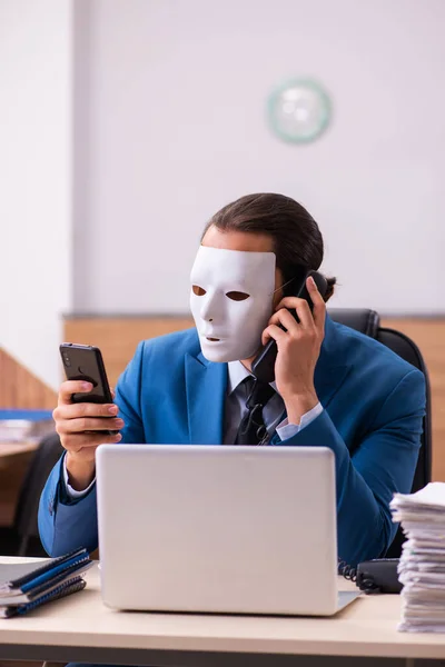 Fiatal férfi alkalmazott maszkot visel az irodában — Stock Fotó