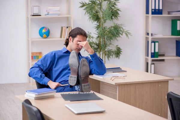 Young male teacher being tired in the classroom — Stock Photo, Image