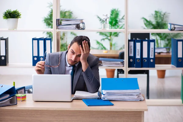 Junge männliche Mitarbeiter und zu viel Arbeit im Büro — Stockfoto