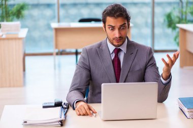 Ofiste çalışan genç bir erkek.