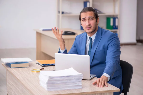 Junge männliche Mitarbeiter und zu viel Arbeit im Büro — Stockfoto