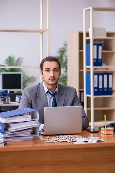 Giovane dipendente malato maschile che soffre sul posto di lavoro — Foto Stock