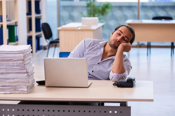 Jovem funcionário masculino infeliz com excesso de trabalho no escritório — Fotografia de Stock