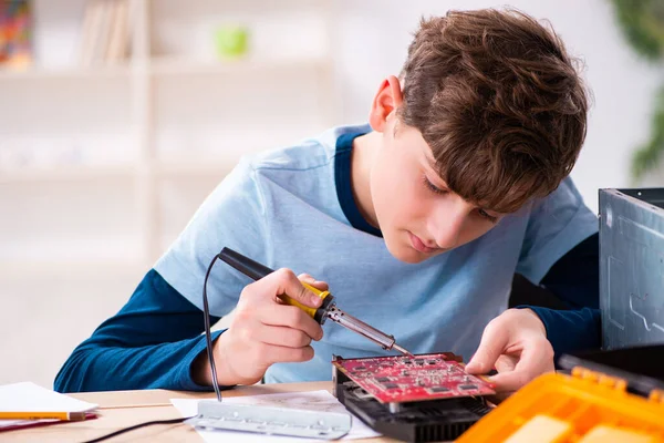 Jongen repareert computers op de werkplaats — Stockfoto