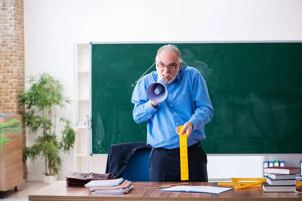 Angry aged male math teacher holding megaphone — Stock Photo, Image