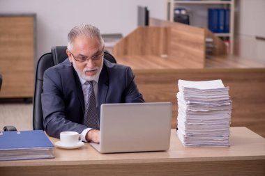 Ofiste çalışan yaşlı bir erkek.