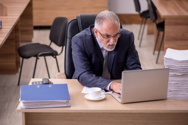 Ofiste çalışan yaşlı bir erkek.