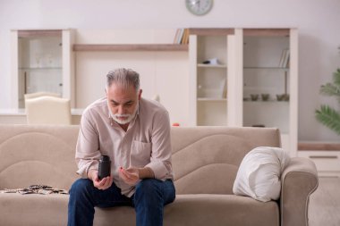 Yaşlı hasta adam evde acı çekiyor.