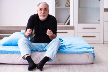 Yaşlı adamın yatak odasında parası bitiyor.