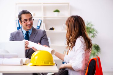 Genç işadamı ve bayan mimar yeni projeyi tartışıyor