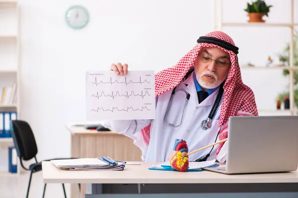 Homem velho árabe médico cardiologista que trabalha na clínica — Fotografia de Stock