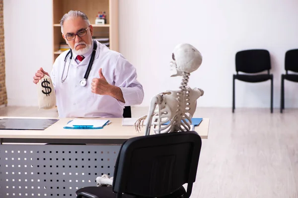 Alte männliche Arzt Kardiologe und Skelett-Patient in teuren m — Stockfoto