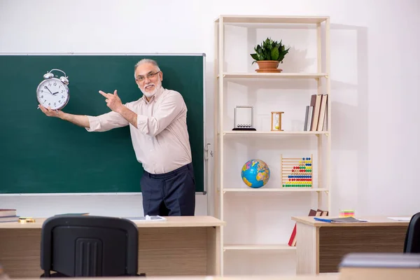 Oude mannelijke leraar in time management concept — Stockfoto