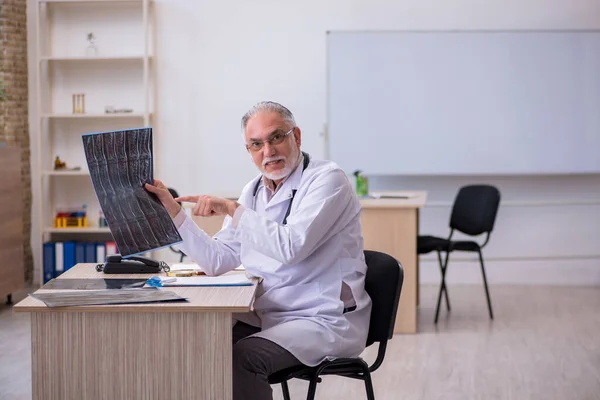 Klinikte çalışan yaşlı bir erkek radyolog. — Stok fotoğraf