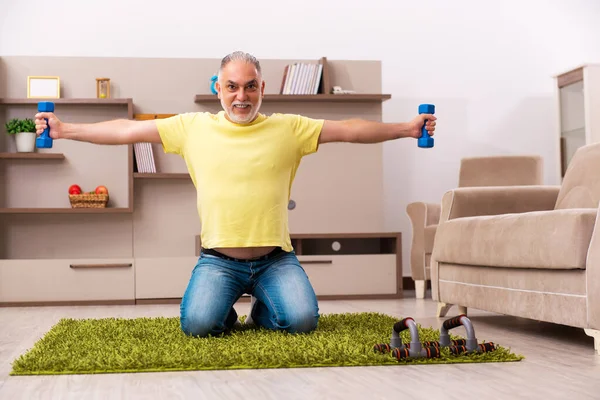 Älterer Mann macht zu Hause Sport — Stockfoto