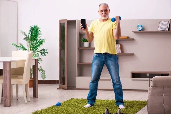 Hombre anciano haciendo ejercicios deportivos en casa — Foto de Stock