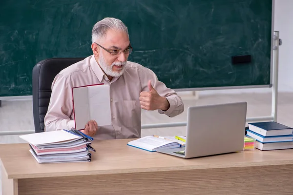 Viejo profesor sentado en el aula — Foto de Stock