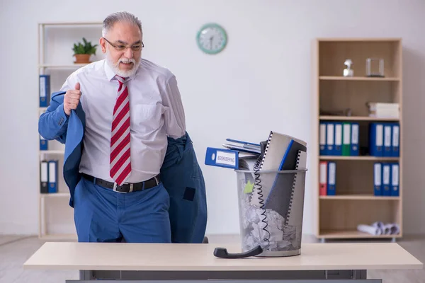 Old businessman employee rejecting new ideas with lots of papers