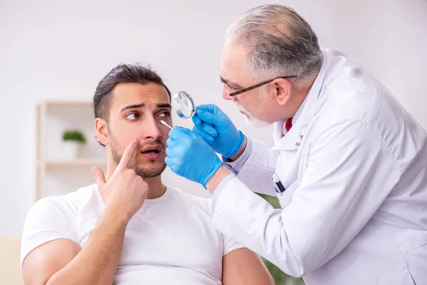 Junger Mann besucht erfahrenen Dermatologen — Stockfoto