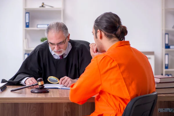 Old male judge meeting with young captive in courthouse — Stock Photo, Image