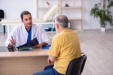 Yaşlı hasta, genç erkek doktor radyolojisti ziyaret ediyor.