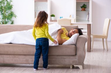 Küçük kız hasta babasına bakıyor.