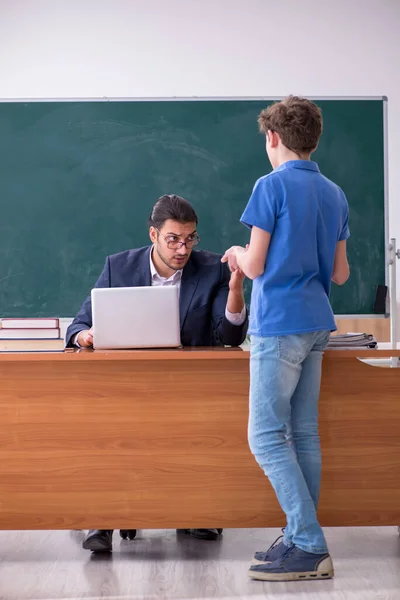 Young male teacher and schoolboy in the classroom — Stock Photo, Image