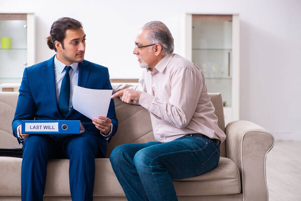 Young male lawyer visiting old man in testament concept