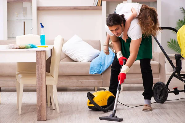 Joven contratista masculino limpiando la casa con su hija pequeña — Foto de Stock