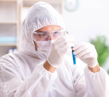 Laboratuvarda kimyasallar üzerinde çalışan genç bir kimyager.