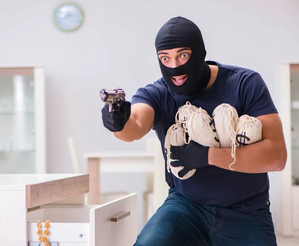 Ladrão usando balaclava roubando coisas valiosas — Fotografia de Stock