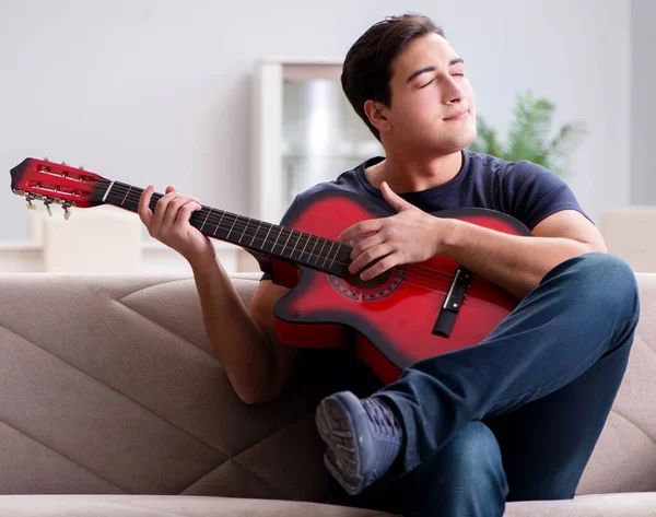 Giovane uomo che pratica la chitarra a casa — Foto Stock