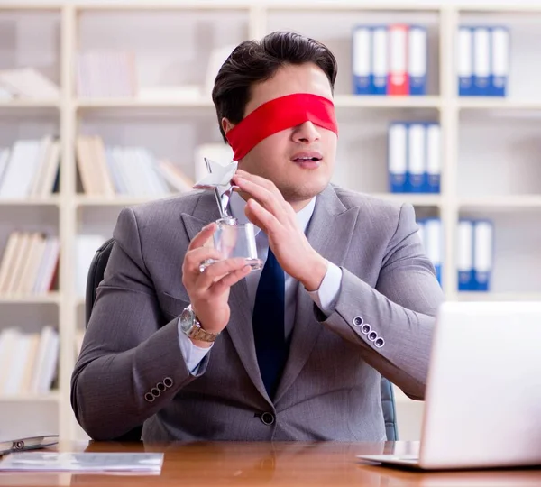 Homme d'affaires les yeux bandés assis au bureau — Photo