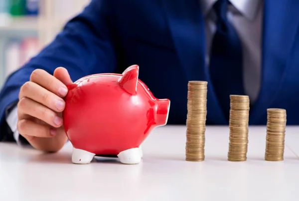 Businessman with stacks of coins in the office — Stock Photo, Image