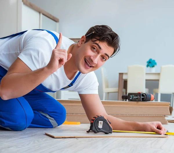 Repairman laying laminate flooring at home — Stock Photo, Image