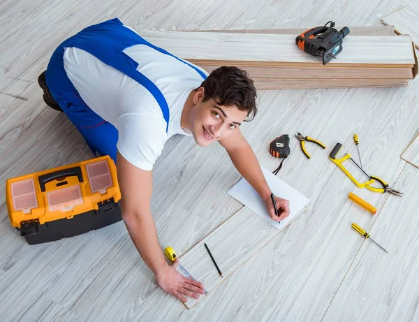 Reparador que estabelece piso laminado em casa — Fotografia de Stock