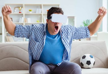 Sanal gerçeklik gözlüğü takan bir adam futbol maçı izliyor.