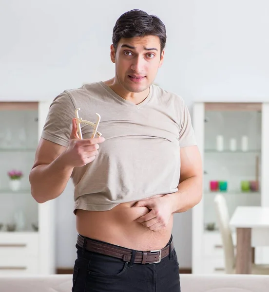 Hombre midiendo grasa corporal con pinzas — Foto de Stock