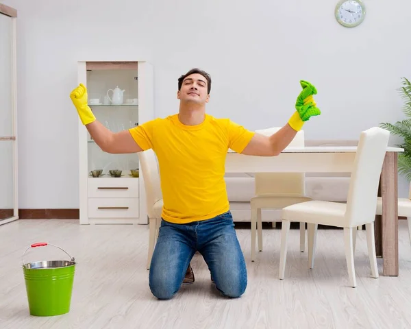 Een man die het huis schoonmaakt en zijn vrouw helpt — Stockfoto