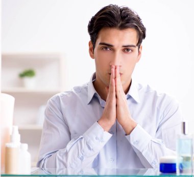 Adam banyoda çalışmak için giyiniyor.