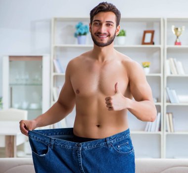 Kilo verme konseptinde büyük beden pantolon giyen bir adam.