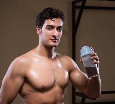 Spor salonunda besin takviyesi olan bir adam.