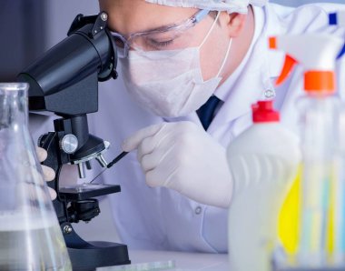 Laboratuvardaki adam yeni temizlik çözeltisi deterjanı test ediyor.