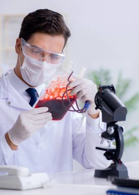 Hastane kliniğinde kan örnekleriyle çalışan bir doktor.