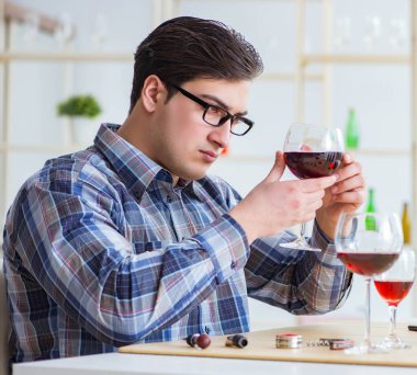 Profesyonel şarap garsonu kırmızı şarap tadıyor.