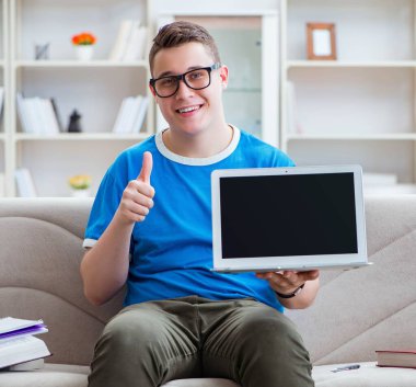 Sınavlara hazırlanan genç öğrenci kanepede ders çalışıyor.