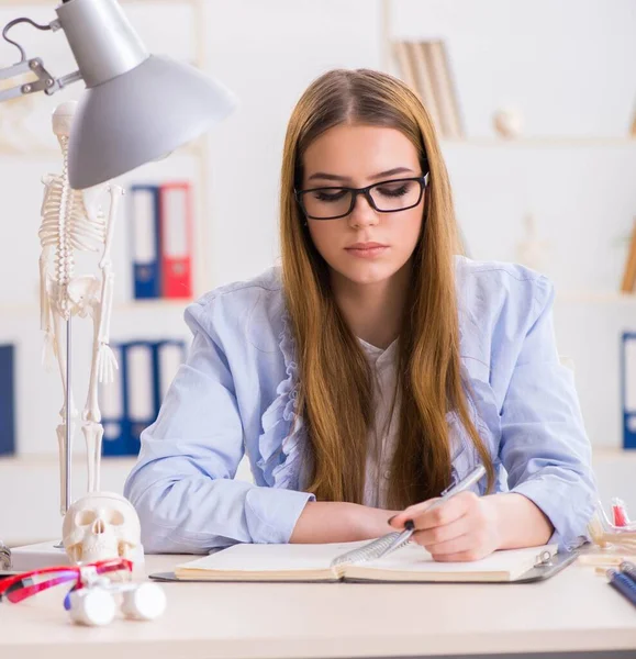 Studente seduto in classe e studiare scheletro — Foto Stock