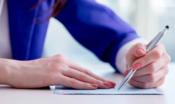 Zakenvrouw schrijft briefjes aan balie — Stockfoto