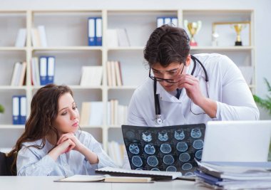 Doktor hastanın röntgen sonuçlarına açıklama yapıyor.
